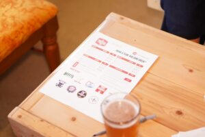 trivia sheet and glass of beer on table
