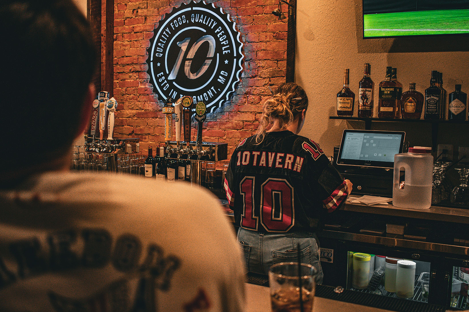 10Tavern bartender wearing a 10Tavern jersey behind the bar