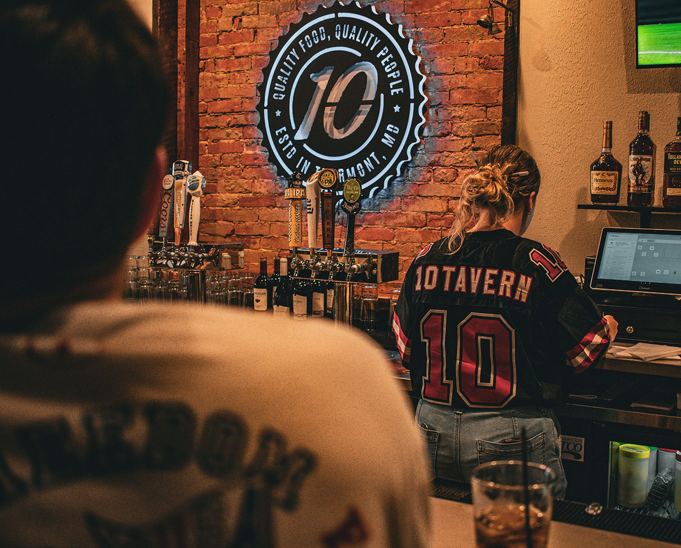 10Tavern bartender wearing a 10Tavern jersey behind the bar